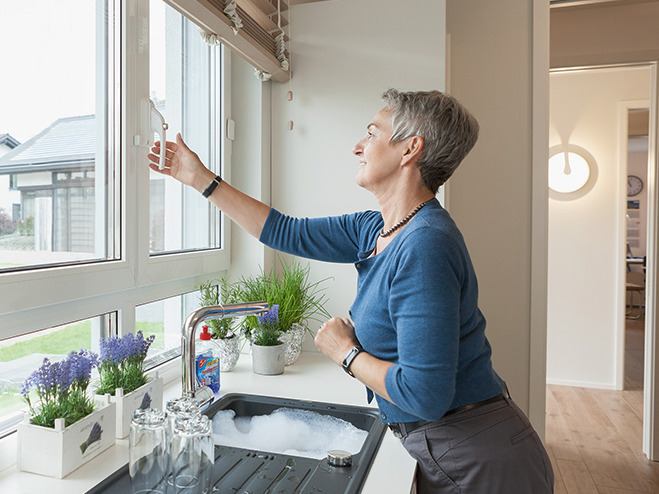 Eine Frau öffnet ihr Fenster in der Küche